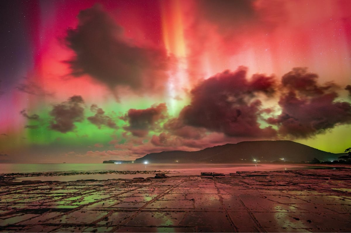 a photo of the aurora borealis above some mountains