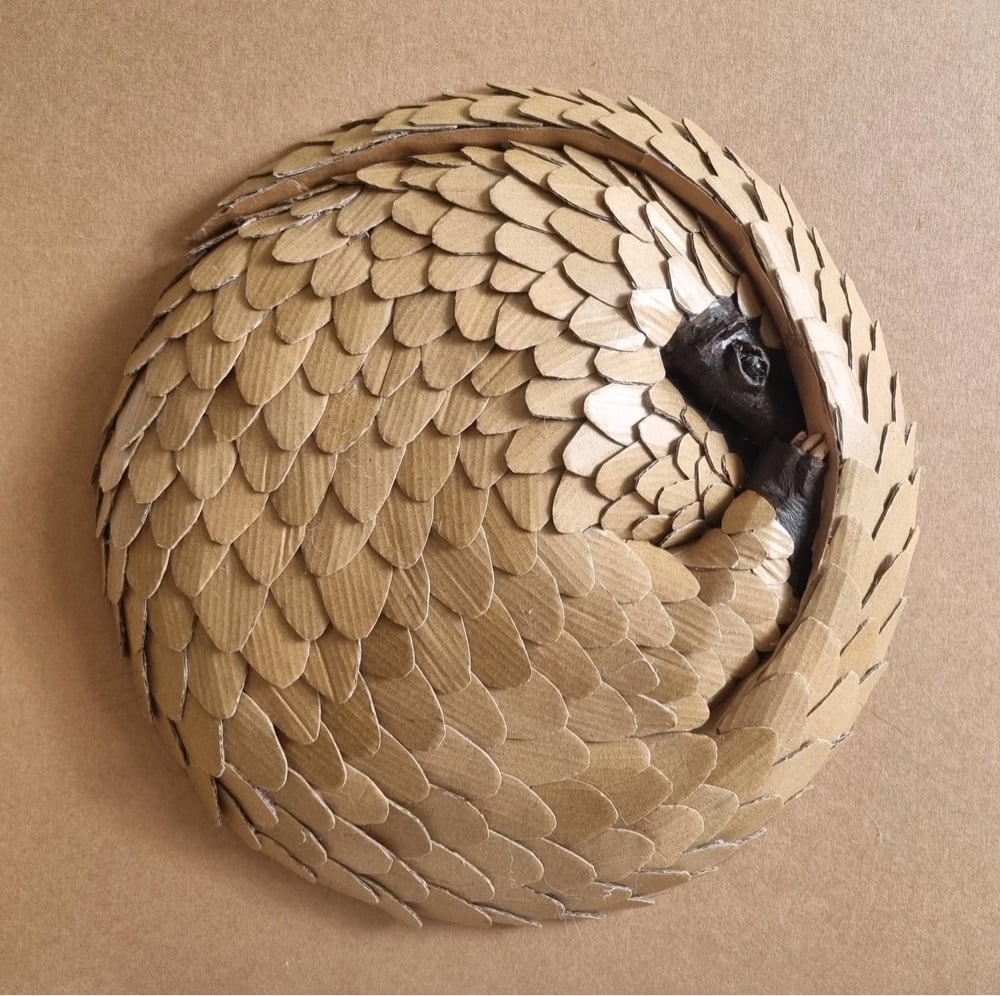 a pangolin sculpture made from cardboard