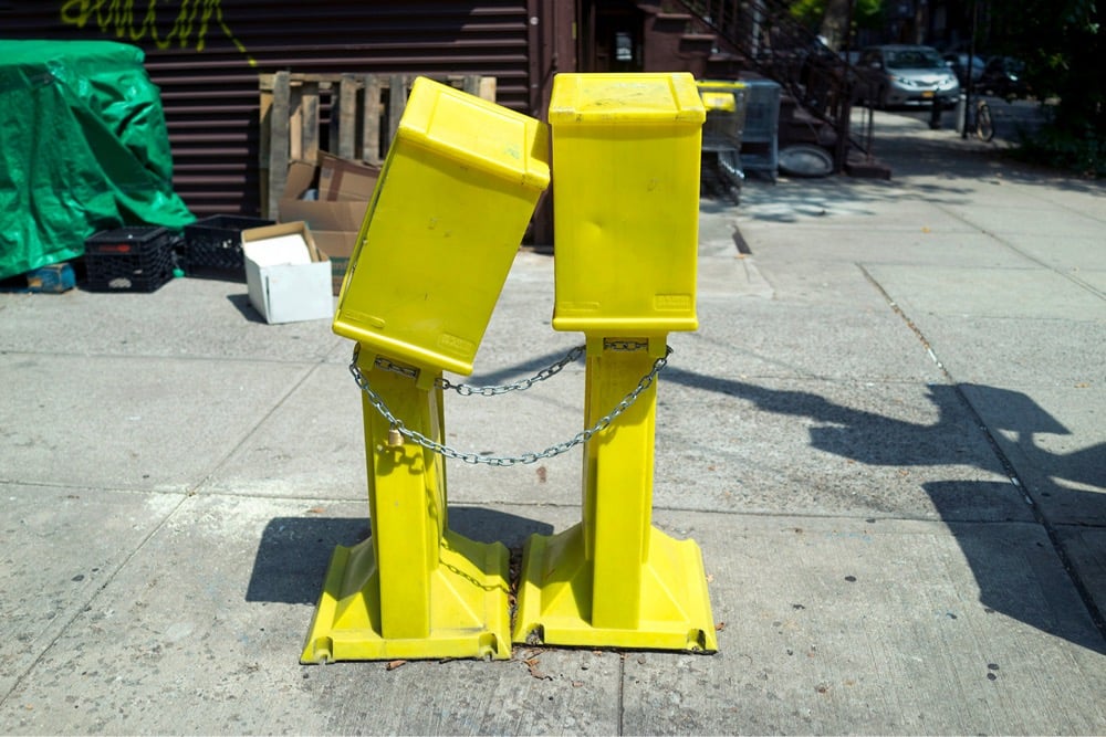 two newspaper boxes cozying up to each other