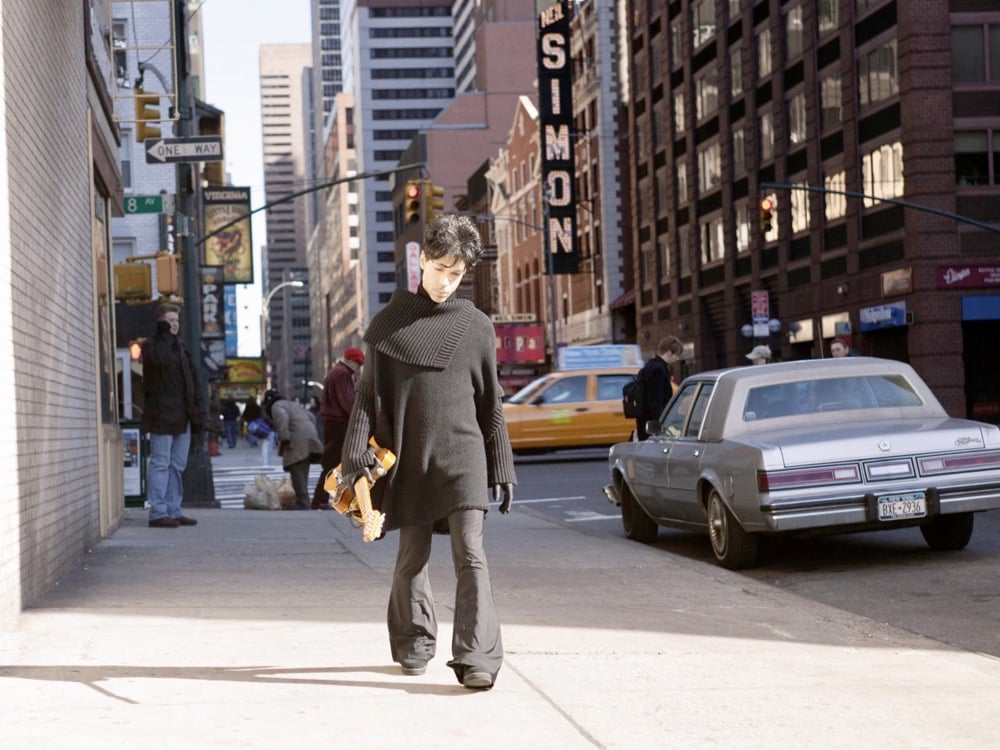 Prince walking in NYC with his guitar in hand