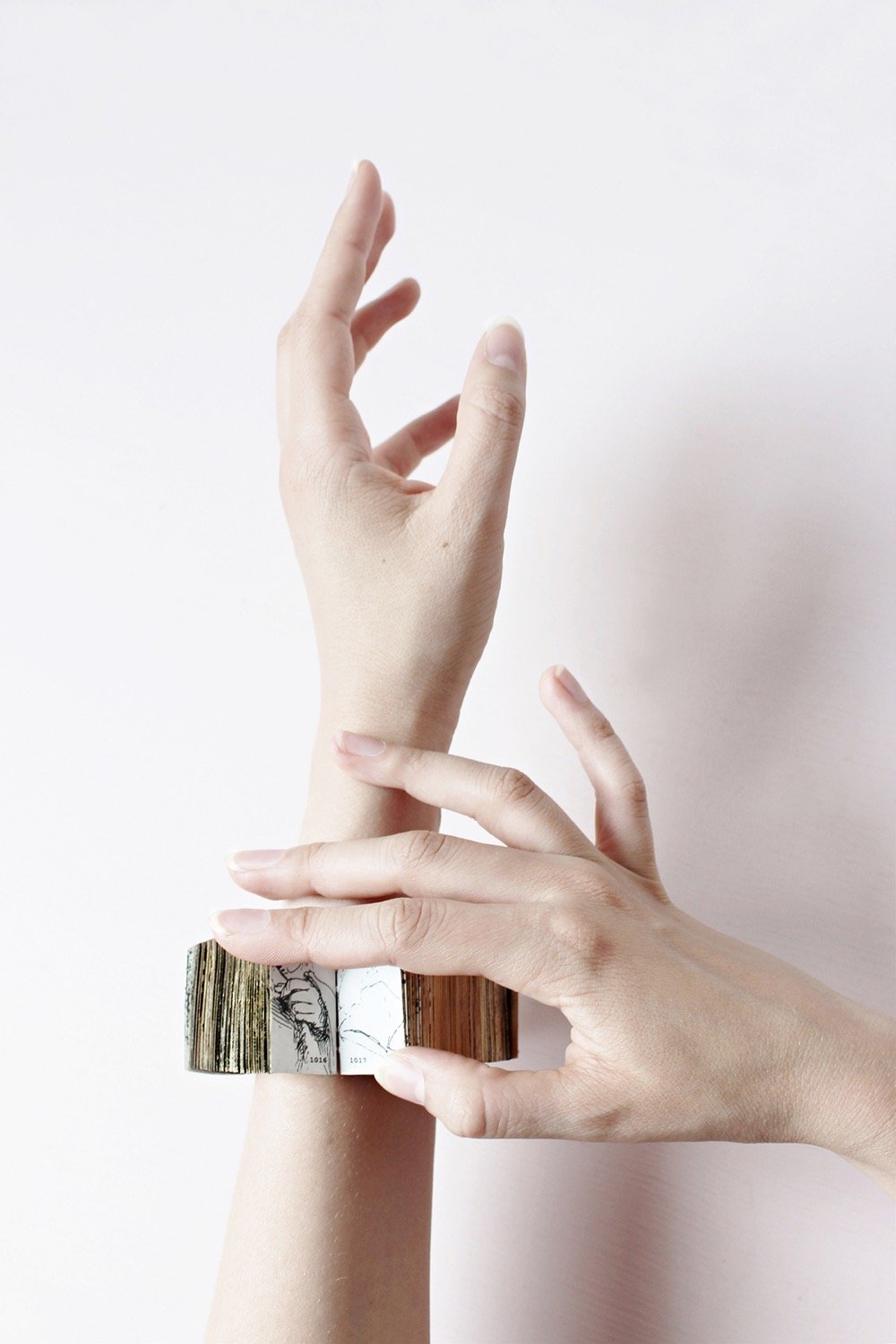 a bracelet made out of tiny Rembrandt drawings of hands being worn on someone's wrist