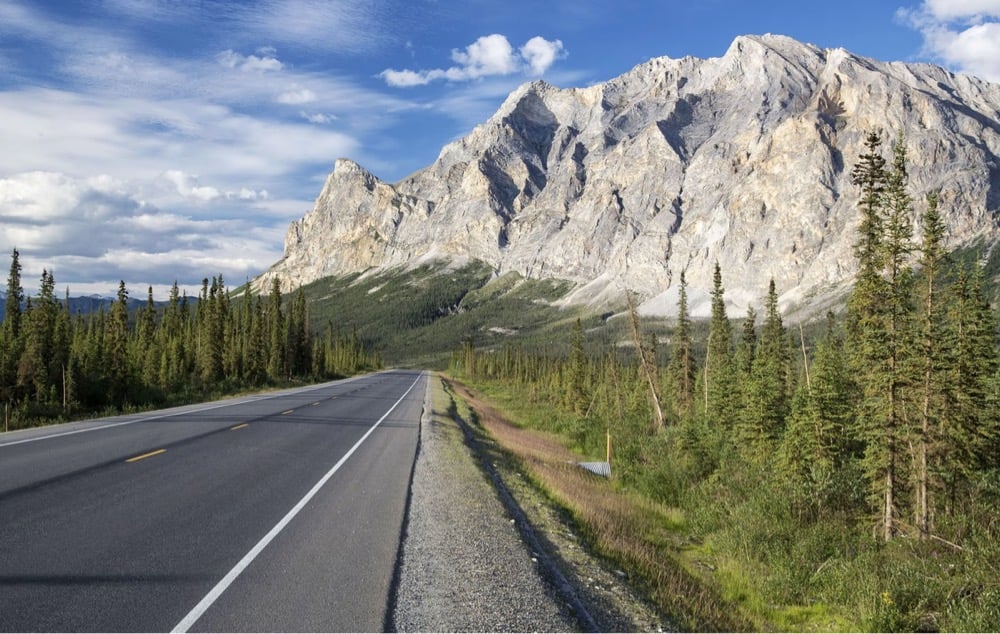 a road with rugged moutains in the background