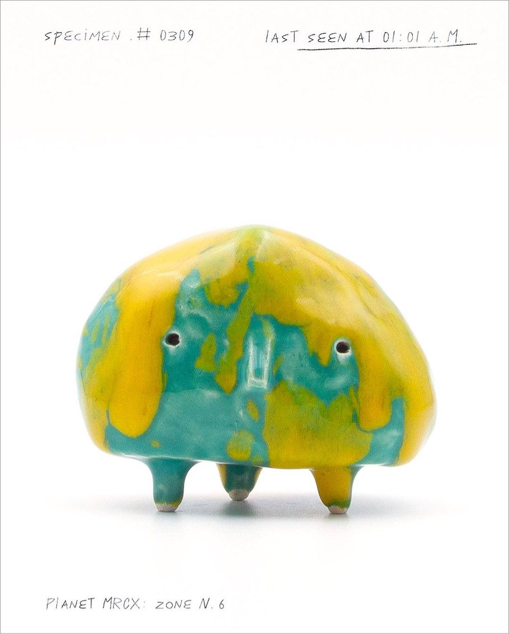 a yellow & green ceramic alien