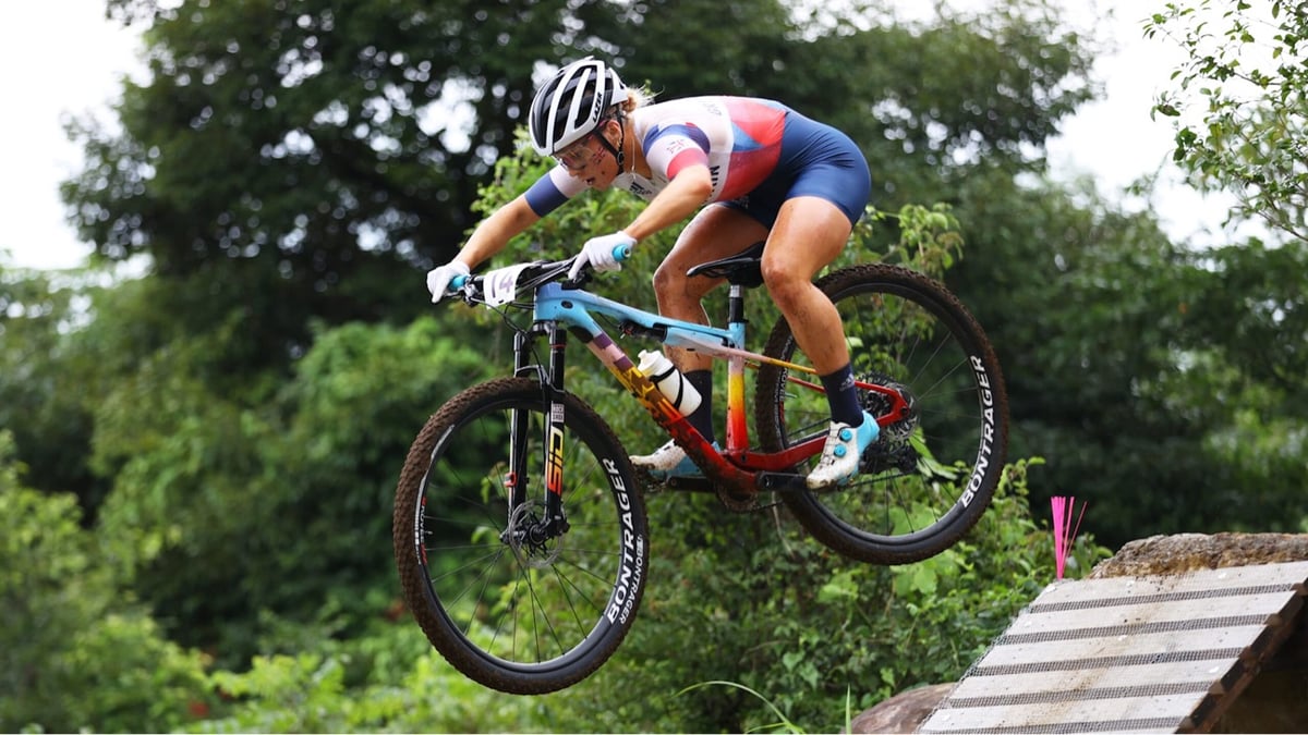 a woman going off a jump on a mountain bike