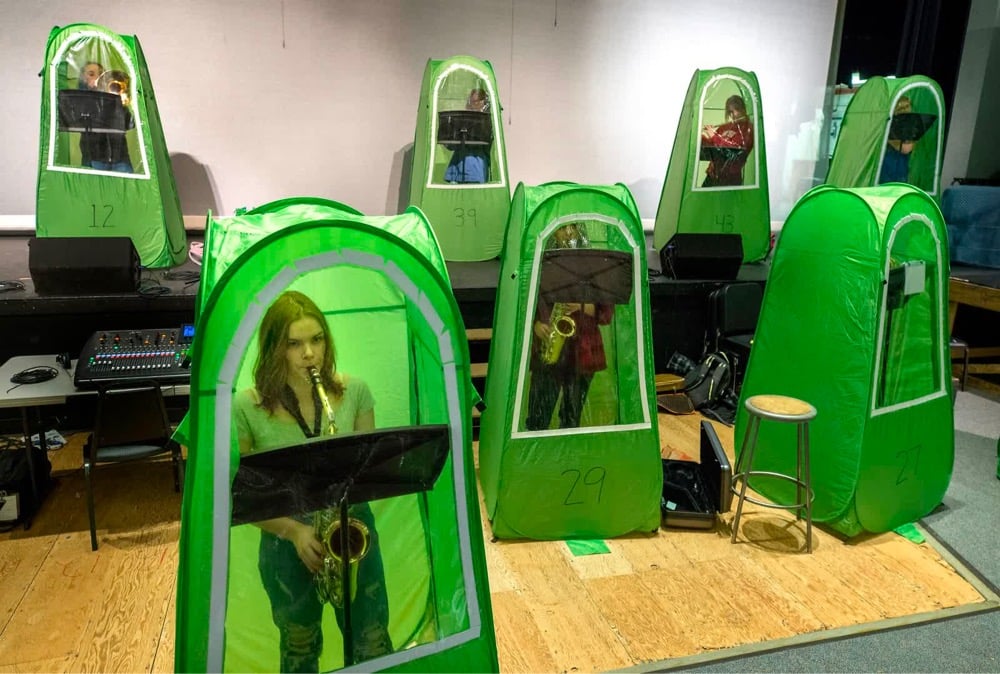 a school band rehearses, each in an individual airtight pod