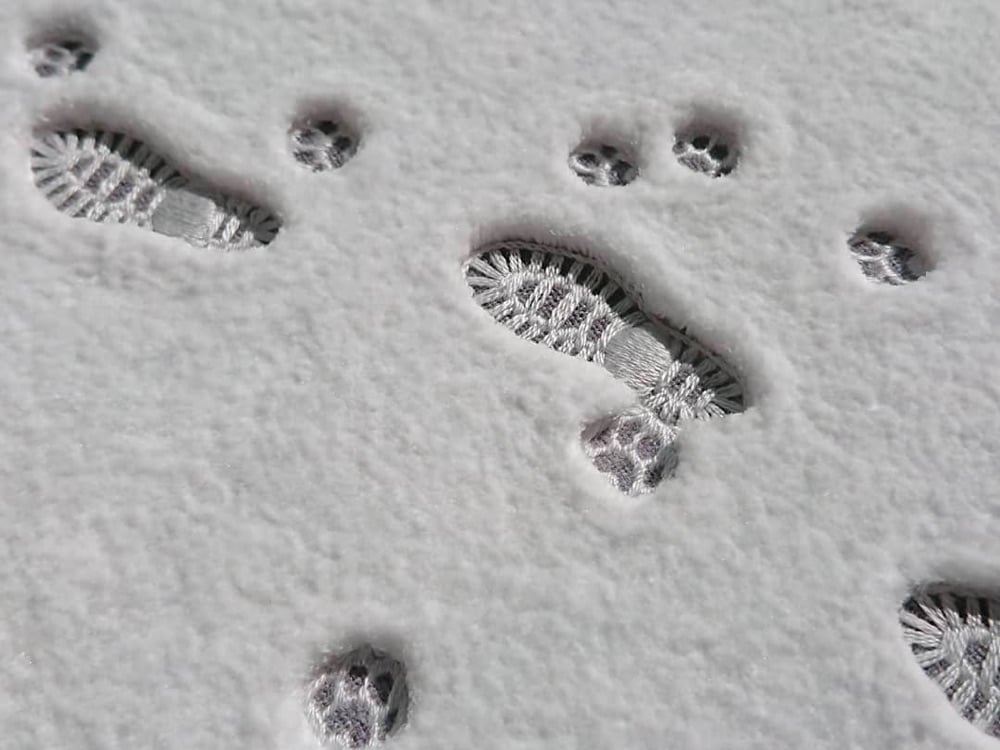 detail of an embroidery that looks like footsteps in the snow